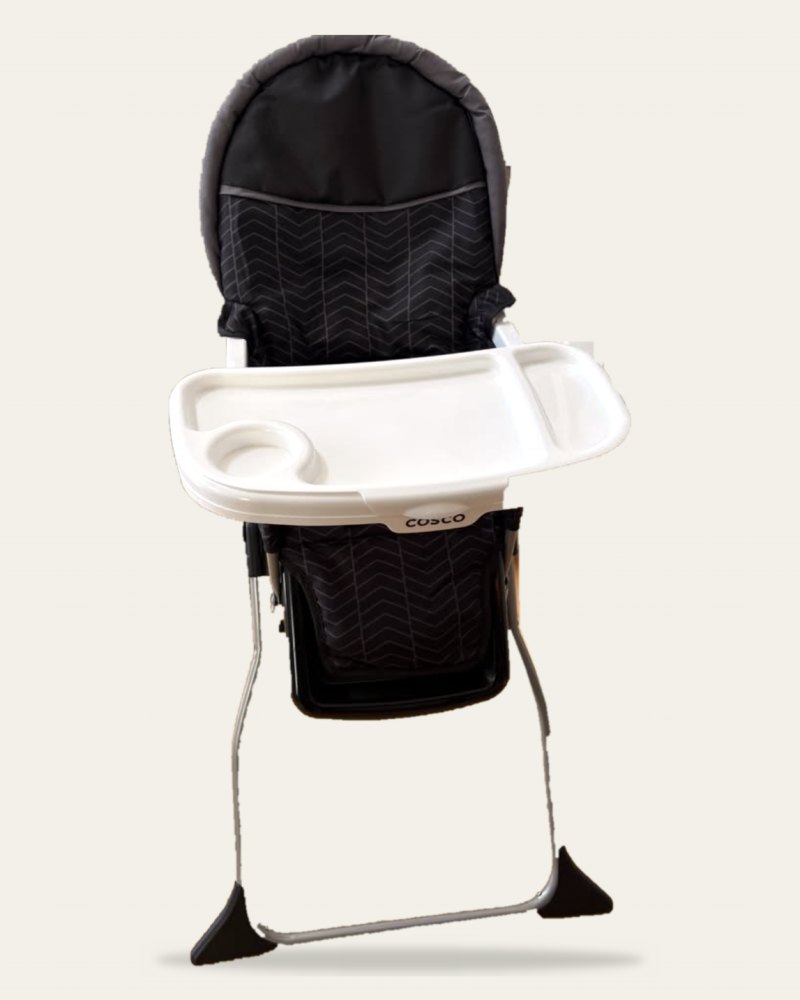 A folding high chair with a dark patterned seat and a white tray