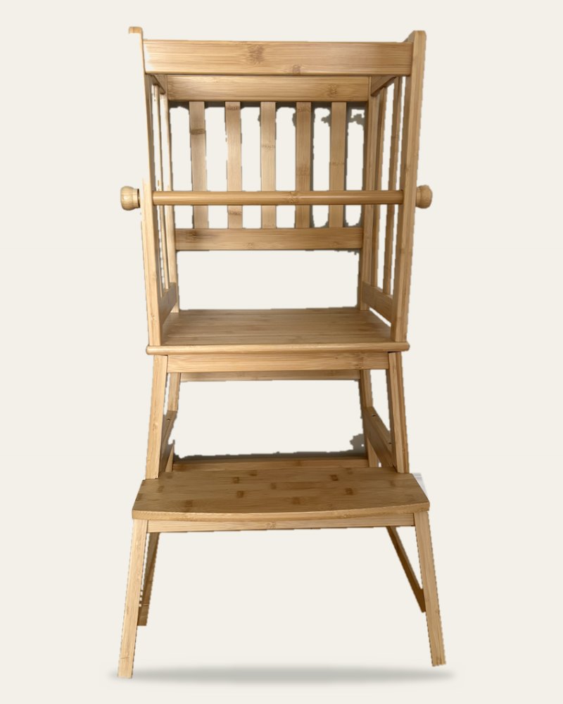 A bamboo toddler tower with a standing platform and side rails